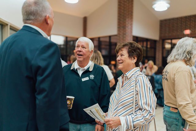 Grandparents talking with a staff member after checking in.