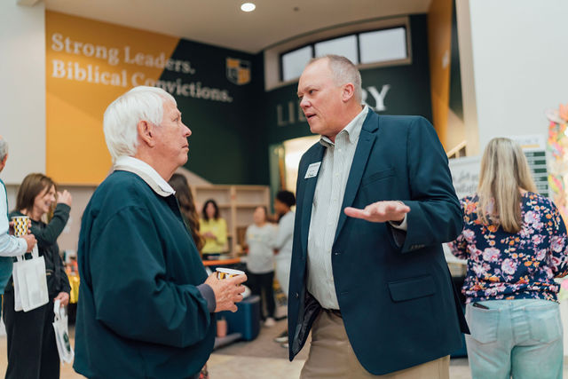 A grandparent talking with a staff member in the school lobby.