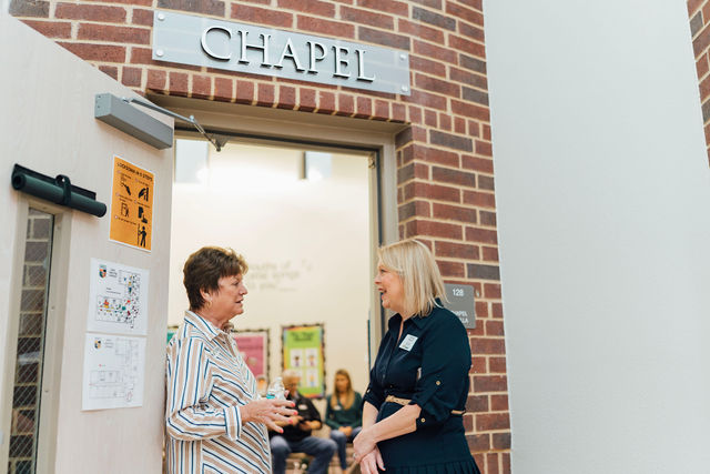 A guest talking with a staff member outside the Chapel.