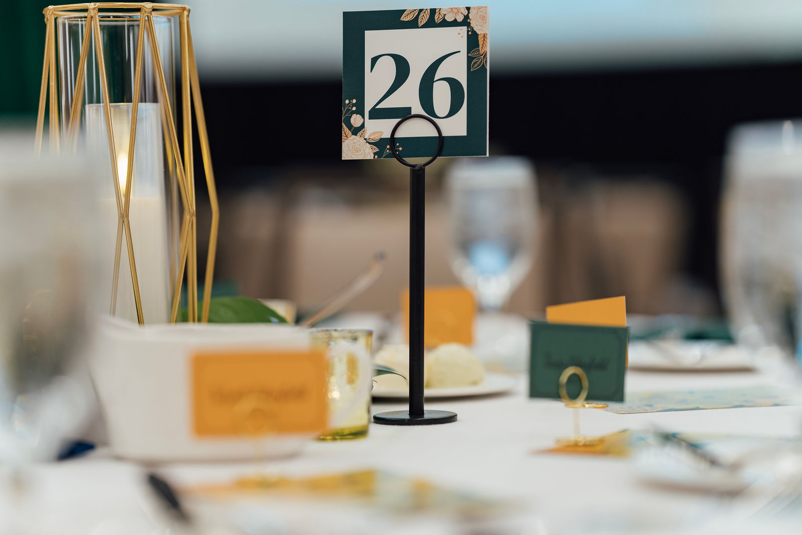 Elegant Legacy Night table setting with gold lantern and green floral place card