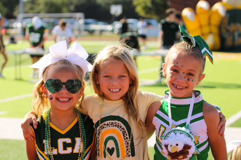Three LCA students smiling together at an outdoor school spirit event