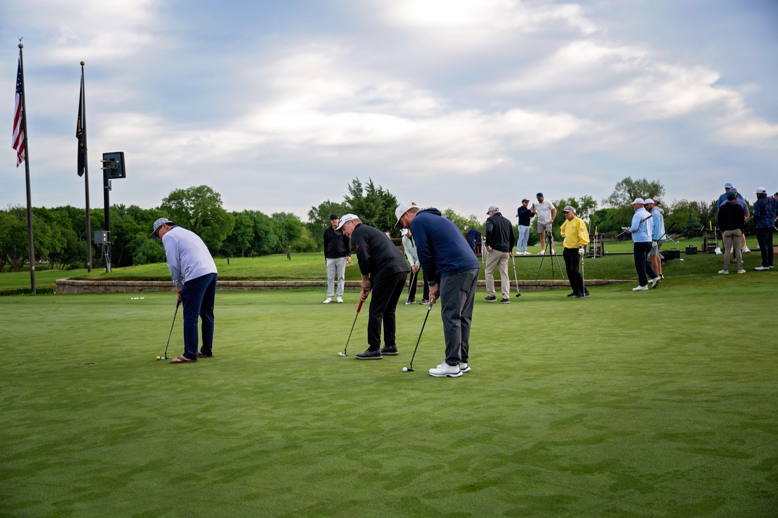 Players practicing putting on the green